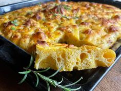 a casserole with cheese and herbs on a black tray, ready to be eaten