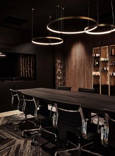 an empty conference room with wooden walls and lighting fixtures hanging from the ceiling above it