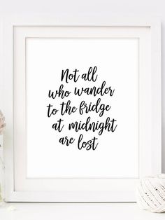 a white framed print with the words not all who wander to the fridge at midnight are lost