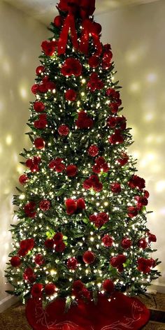 a christmas tree decorated with red roses and lights