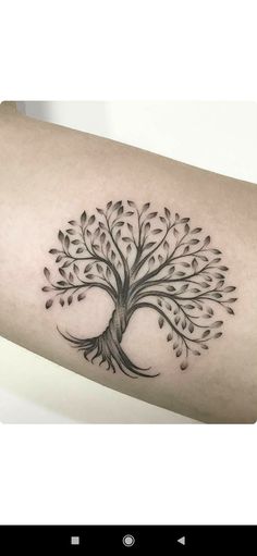 a black and white tree tattoo on the arm