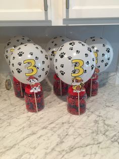 three balloons with paw prints on them sitting on a counter