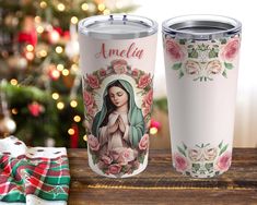 two personalized travel mugs sitting next to a christmas tree