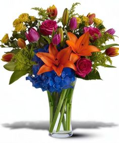 a vase filled with colorful flowers and greenery