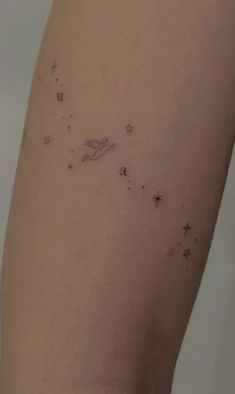 a woman's thigh with stars and an angel tattoo on it