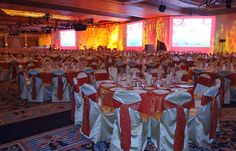 a banquet hall with tables and chairs covered in red, white and gold cloths