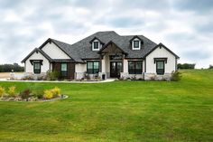 a large house on a green field with trees in the background