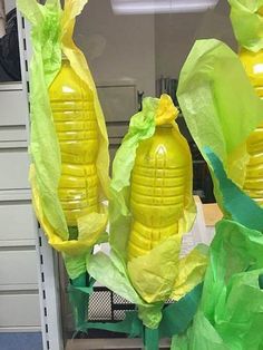 three yellow plastic vases with green paper wrapped around them