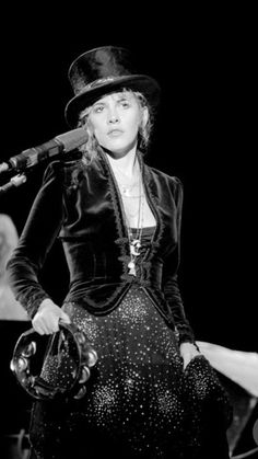 a woman wearing a top hat and holding a microphone