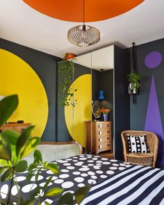 a bedroom decorated in black, white, and yellow with polka dots on the walls