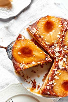 a pineapple upside down cake on a plate with two slices cut out and ready to be eaten