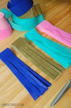 several different colored pieces of fabric sitting on top of a wooden table