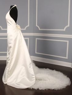 a white wedding dress on display in a room