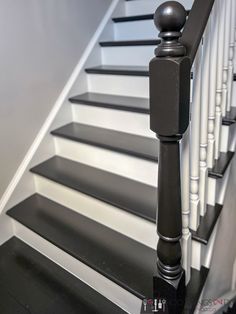 a black and white stair rail next to a set of stairs