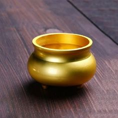 a gold vase sitting on top of a wooden table