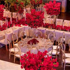 the tables are set with white linens and red flowers