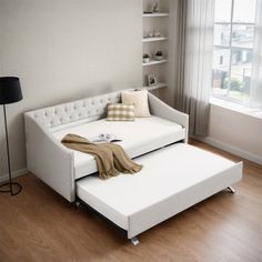 a living room with a white couch and ottoman