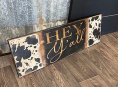 a wooden sign that says hey girl with gold paint splattered on it's side