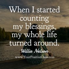 a woman sitting on top of a wooden dock next to water with the words when i started counting my blessing, my whole life turned around willie nelson