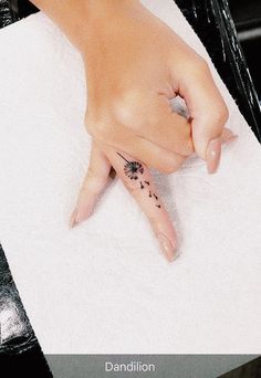 a person's hand on top of a towel with a flower tattooed on it