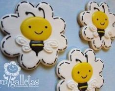 three decorated cookies in the shape of flowers with bees on them, sitting on a blue background