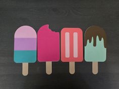 three popsicles with different colored ice cream on them