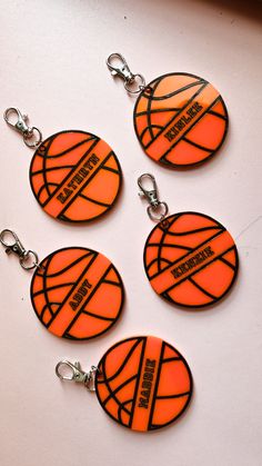 four basketball keychains are shown on a table