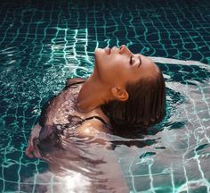 a woman is floating in the water with her head above the water's surface