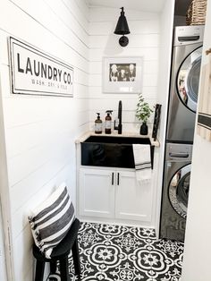 a washer and dryer in a small room with black and white flooring