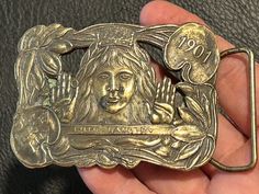 a gold belt buckle with an image of the virgin mary