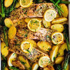 salmon, potatoes and asparagus in a white casserole with lemons