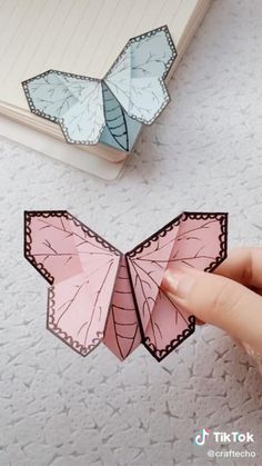 someone is making an origami butterfly out of paper