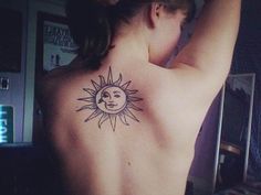 a woman with a sun tattoo on her back