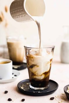 ice cream being poured into a glass with coffee beans around it and the caption four the espresso mixture over ice and top with the oat milk