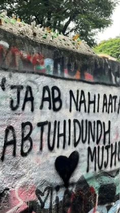 graffiti on the side of a wall with words written in black and white writing,