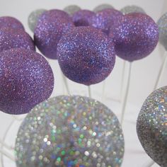 purple and silver cake pops with glitter on them