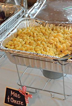 macaroni and cheese is being served in an aluminum pan on a buffet table