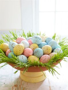 a bowl filled with eggs sitting on top of a table next to a planter