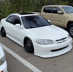 two white cars parked next to each other in a parking lot