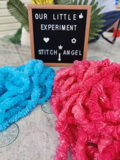 three different colored scrubcloths sitting on top of a table next to a sign that says our little experiment stitch angel