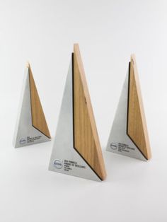 three wooden and metal triangular trophies on white background with clipping to each other's sides