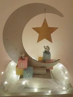 a baby's room with a moon, stars and blocks on the shelf in front of it