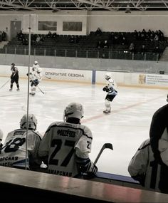 an ice hockey game in progress with the players on the sidelines and fans watching