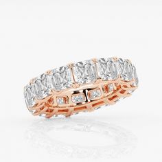 a rose gold and white diamond ring with three rows of baguetts on each side