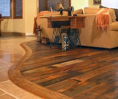 a living room filled with furniture and a wooden floor covered in hard wood planks