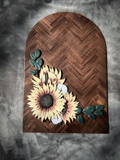 a wooden cutting board with sunflowers and leaves cut out of it's sides