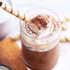 there is a drink with whipped cream and cinnamon on the rim in a glass jar