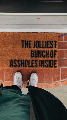 someone standing in front of a door with their feet up on the rug that says, the jolliest bunch of ashbles inside