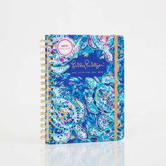 a spiral notebook with an intricate blue and white design on the front, featuring colorful flowers