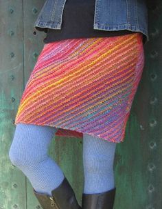 a woman wearing boots and a colorful knitted skirt